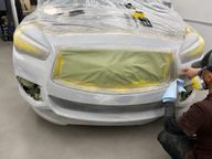Technician preparing a bumper for paint in our Pompano Beach shop